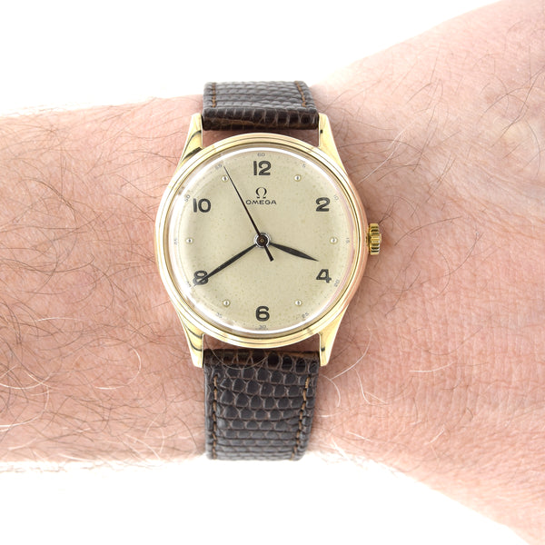 Vintage Omega watch with brown strap on a wrist
