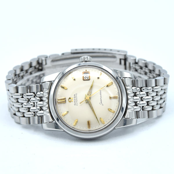 Omega x Swatch Stratomeister wrist watch with a silver-tone stainless steel link bracelet, a cream-colored dial, and gold-tone hands and hour markers.