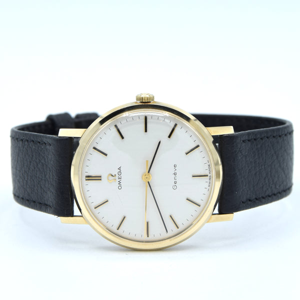 Omega Geneva wristwatch with a gold-tone round case, white dial, and black leather strap, shown against a plain white background.
