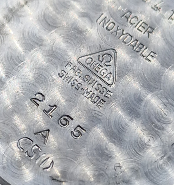 Close-up of Omega watch caseback with branding and text