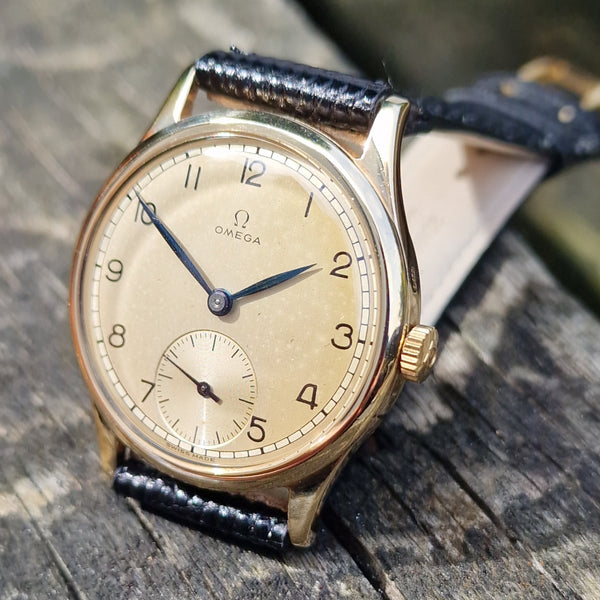 Vintage wristwatch with leather strap on a wooden surface