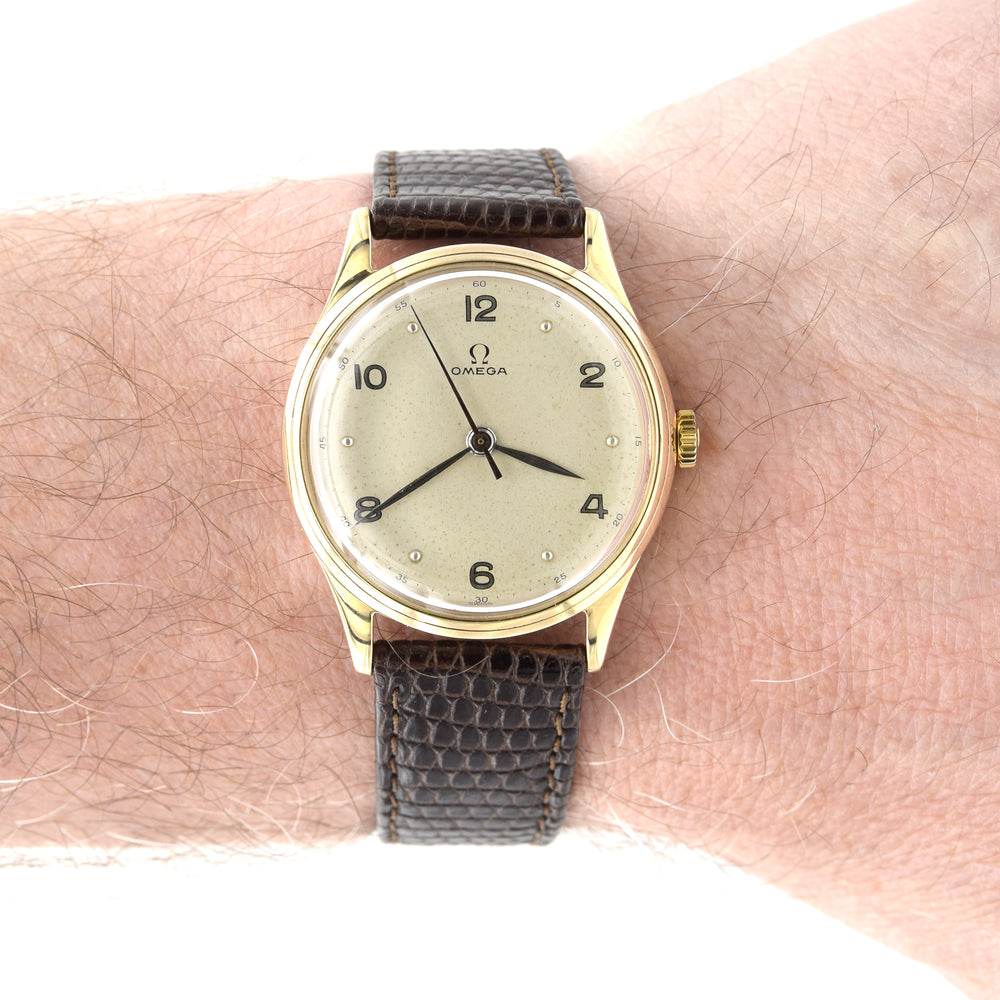 Vintage Omega watch with brown strap on a wrist
