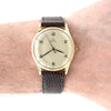 Vintage Omega watch with brown strap on a wrist