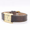 Gold watch with brown leather strap on a white background