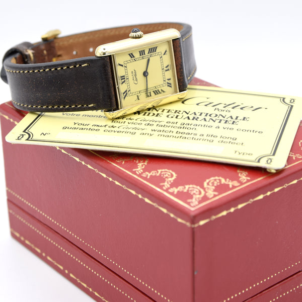 Cartier watch with black leather strap on a red box