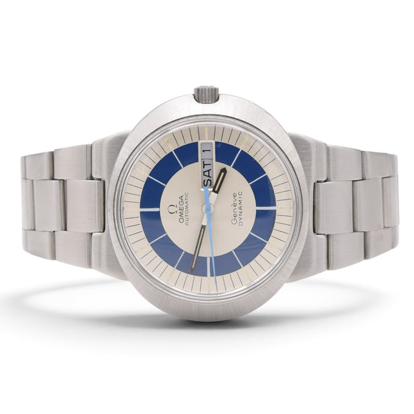 An Omega wrist watch with a stainless steel bracelet, featuring a silver-toned dial, blue concentric ring details, and a blue day indicator, shown on a white background.