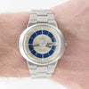 Omega Geneve Automatic wristwatch with a stainless steel link bracelet, featuring a blue and silver dial with a day-date window, shown worn on a wrist.