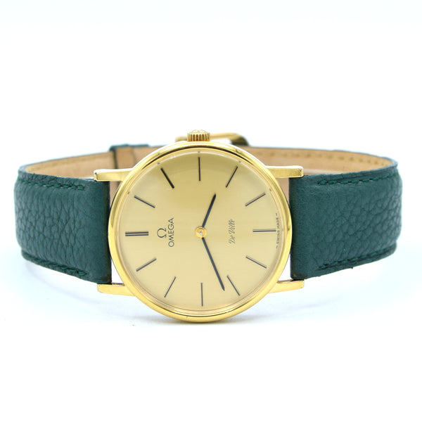 Gold watch with green strap on a white background