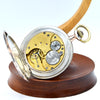 Mechanical watch on a wooden stand with a white background