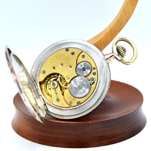 Mechanical watch on a wooden stand with a white background