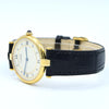 A Cartier watch with a gold-tone case, white dial with Roman numerals, and a black alligator leather strap, displayed on a white background.