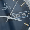 Close-up of an Omega Automatic watch dial with a dark blue sunburst finish, silver hands, gold hour markers, and a day-date window showing SUN 28.