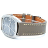 An Omega De Ville watch with a silver-tone rounded rectangular case, a gray dial, and a brown leather strap with light beige contrast stitching, shown on a white background.