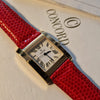 A vintage-style rectangular watch with a bright red textured strap and a gold-tone case, displayed on top of a white Concord paper pad with the Concord logo visible.